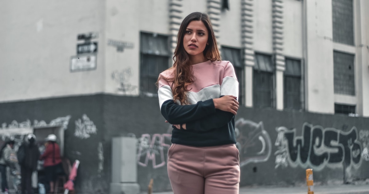 Woman standing on street looking unhappy