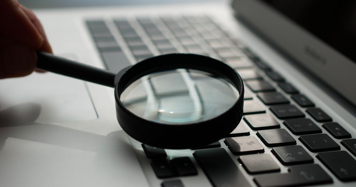 A magnifying glass over a laptop keyboard